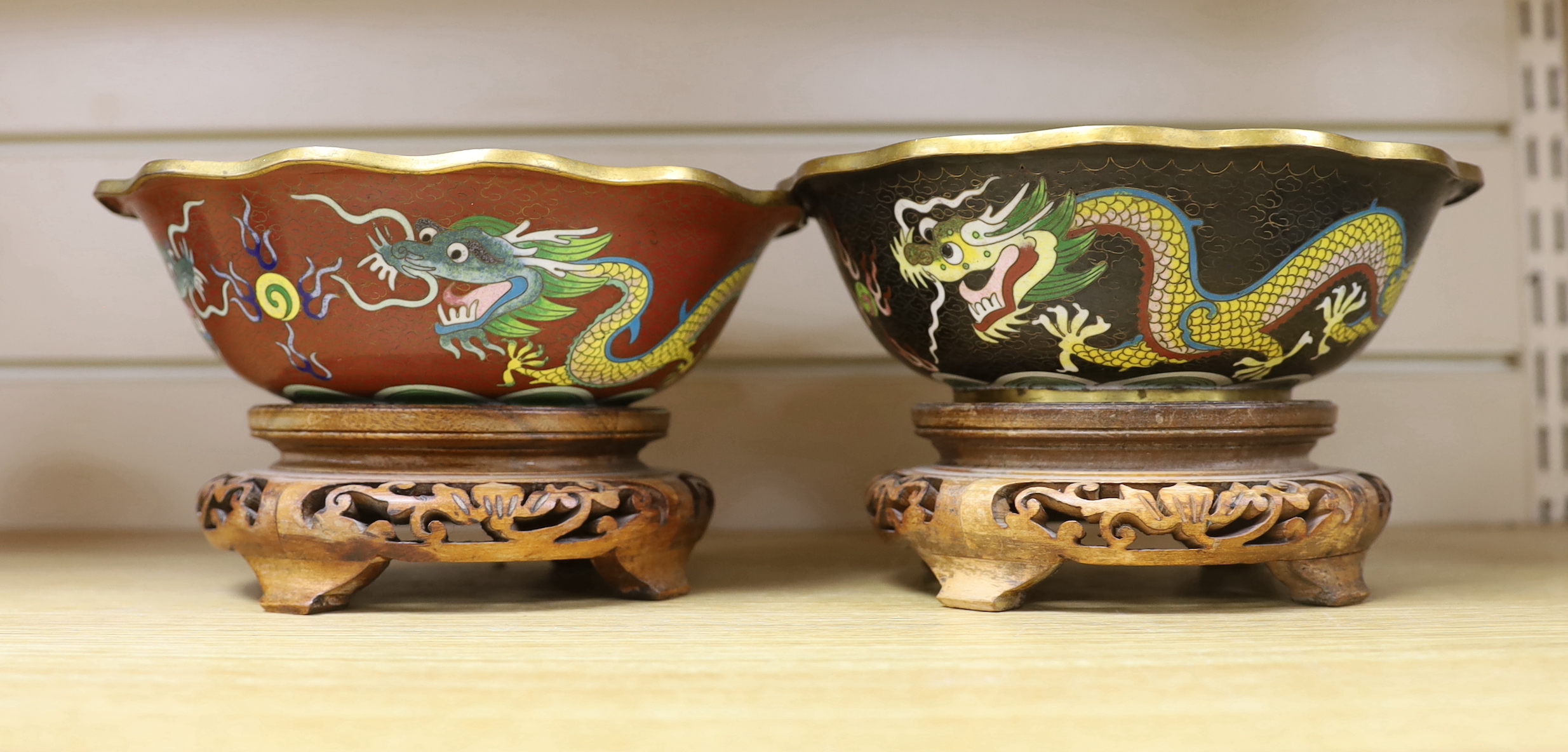 Two Chinese cloisonné enamel bowls on hardwood stands, enamelled with dragons chasing the flaming pearl together with three Star God figures, the largest 20cm in diameter